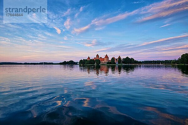 T Castle in lake Galve  Lithuania on sunset with dramatic sky reflecting in water. Castle is one of major tourist attractions of LituaniaTrakai Island
