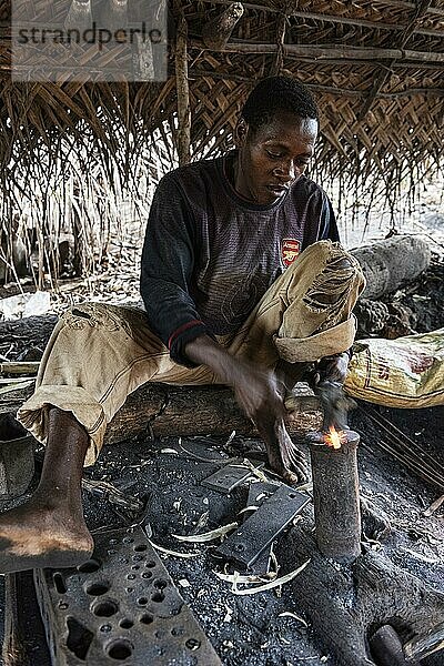 Archaische Schmiede  Handwerker schmiedet unter einem Dach Eisennägel über offenem Feuer  Unguja  Sansibar  Tansania  Afrika