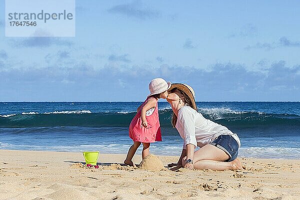 Mother and daughter kissing on the beach  Kauai island  Hawaii