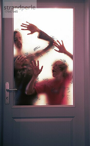Gruselige Silhouette von zwei jungen Erwachsenen im Gegenlicht hinter einer verschlossenen Glastüre  14 Jahre Angst  Verzweiflung  Oberösterreich  Österreich  Europa