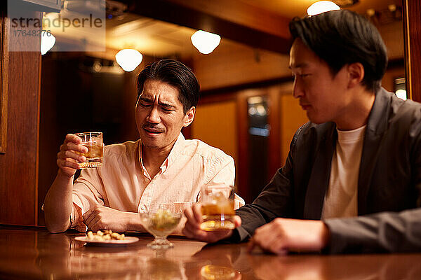 Japanese friends having a drink at a bar counter