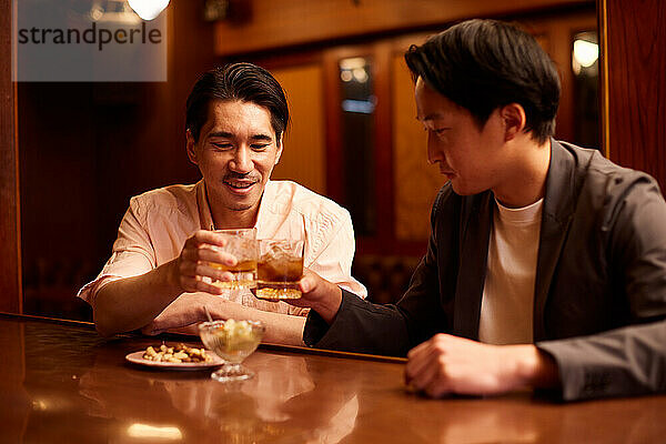 Japanische Freunde trinken an einer Bartheke etwas