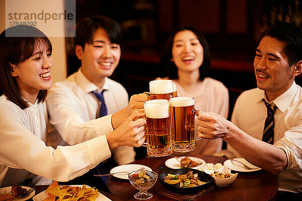 Japanische Geschäftsleute trinken und speisen in einer Bar