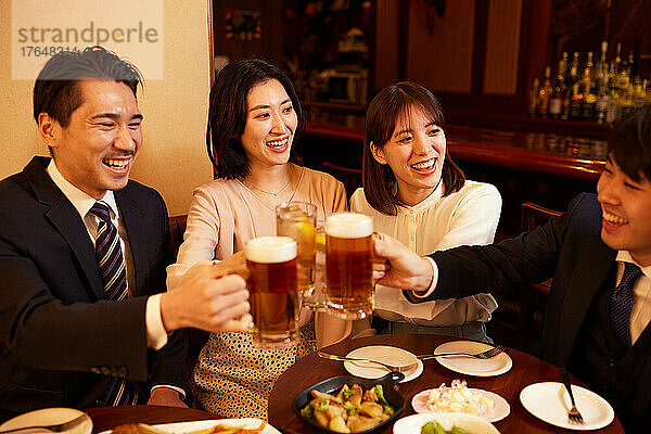 Japanische Geschäftsleute trinken und speisen in einer Bar