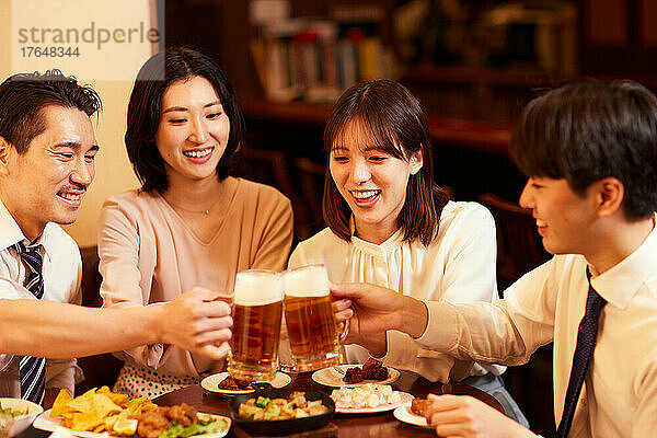 Japanische Geschäftsleute trinken und speisen in einer Bar