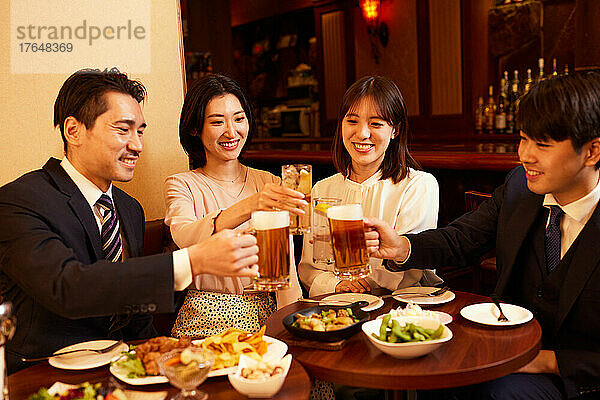 Japanische Geschäftsleute trinken und speisen in einer Bar