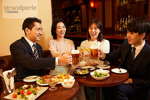 Japanische Geschäftsleute trinken und speisen in einer Bar