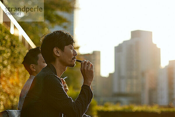 Japanische Männer rauchen draußen
