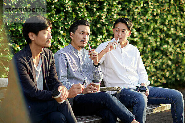 Japanische Männer rauchen draußen