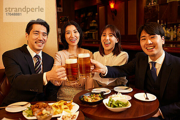 Japanische Geschäftsleute trinken und speisen in einer Bar