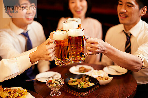 Japanische Geschäftsleute trinken und speisen in einer Bar