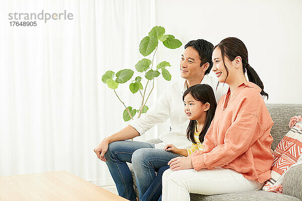 Japanische Familie entspannt auf dem Sofa