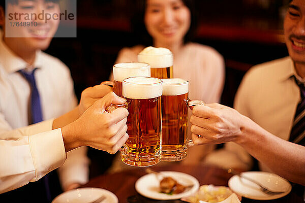 Japanische Geschäftsleute trinken und speisen in einer Bar