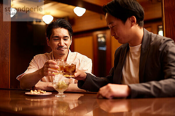 Japanische Freunde trinken an einer Bartheke etwas