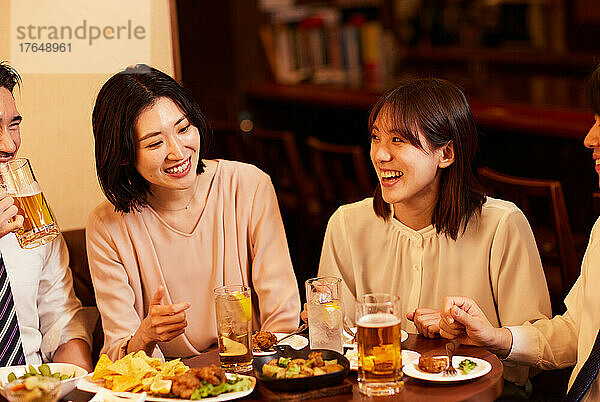 Japanische Geschäftsleute trinken und speisen in einer Bar