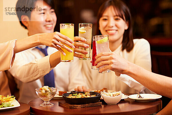 Japanische Geschäftsleute trinken und speisen in einer Bar