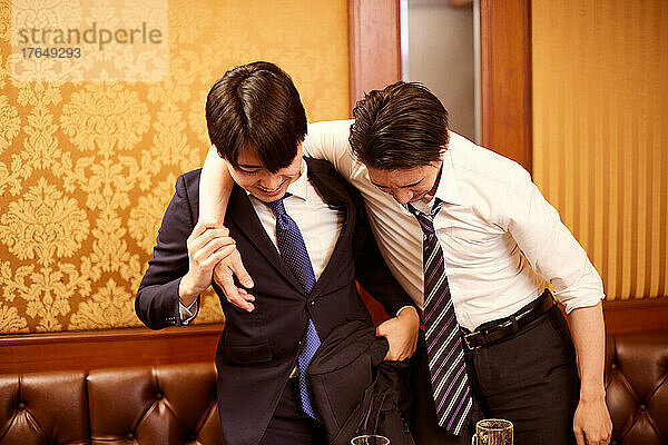 Japanische Geschäftsleute trinken Getränke beim Karaoke