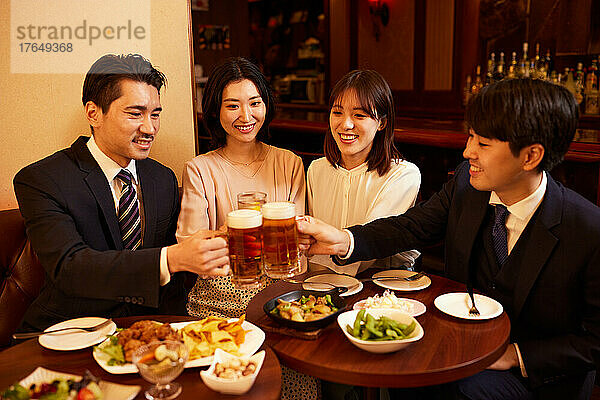 Japanische Geschäftsleute trinken und speisen in einer Bar