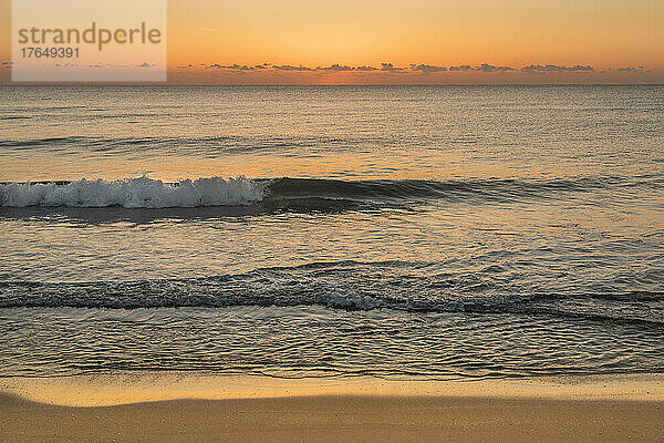 Meereswellen am Strand bei Sonnenaufgang