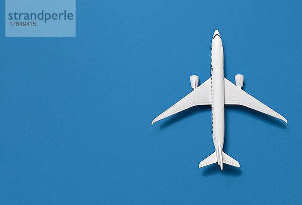 Draufsicht auf ein Flugzeugmodell vor blauem Hintergrund