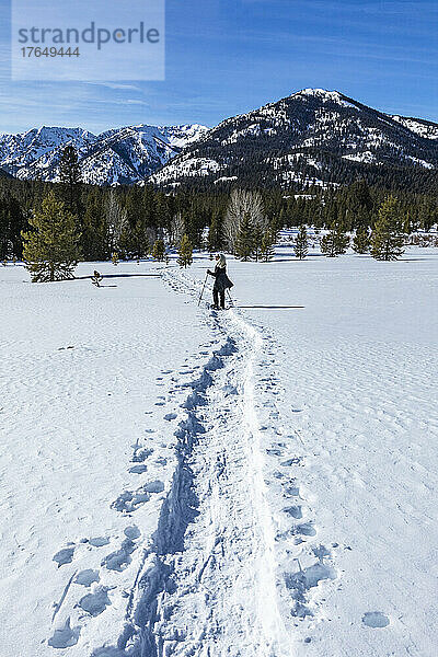 USA  Idaho  Ketchum  Rückansicht einer älteren blonden Frau beim Schneeschuhwandern in der Nähe von Sun Valley im Winter