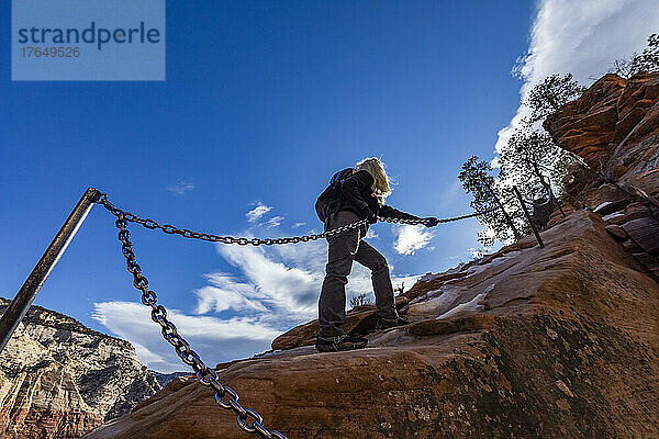 Vereinigte Staaten  Utah  Zion-Nationalpark  Low-Angle-Ansicht einer älteren Frau beim Wandern auf dem Angels Landing Trail im Zion-Nationalpark in Utah