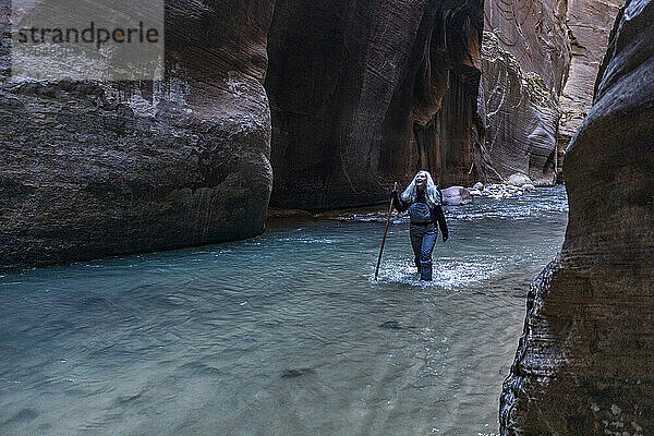 Vereinigte Staaten  Utah  Zion-Nationalpark  Ältere Wanderin watet durch die Narrows des Virgin River im Zion-Nationalpark