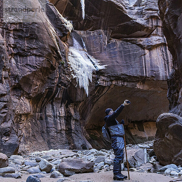 USA  Utah  Zion-Nationalpark  Senior-Wanderer fotografiert Felsformationen an den Narrows of Virgin River im Zion-Nationalpark