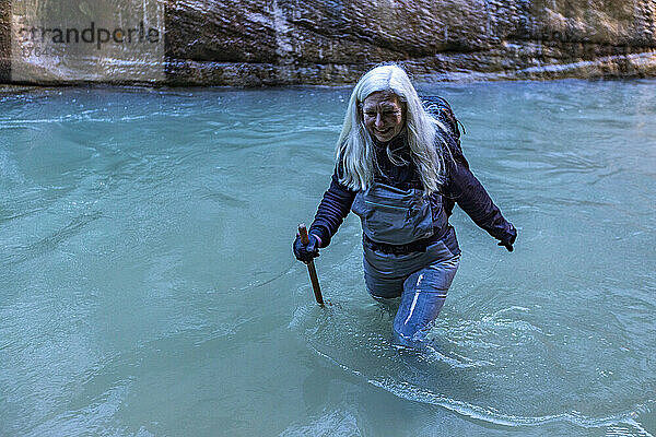 Vereinigte Staaten  Utah  Zion-Nationalpark  Ältere Wanderin watet durch die Narrows des Virgin River im Zion-Nationalpark