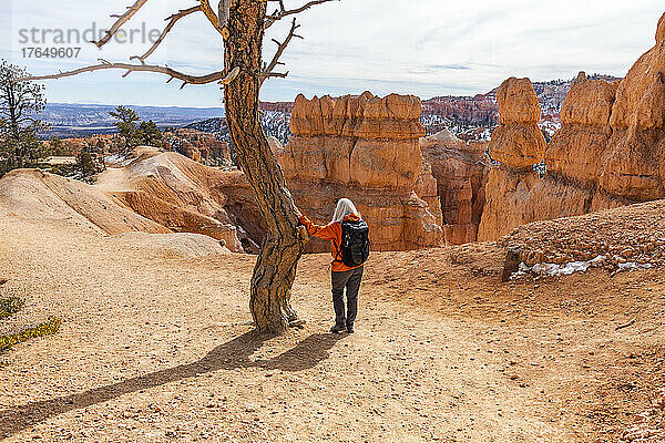 Vereinigte Staaten  Utah  Bryce-Canyon-Nationalpark  Rückansicht einer älteren Wanderin mit Rucksack  die die Aussicht im Bryce-Canyon-Nationalpark betrachtet