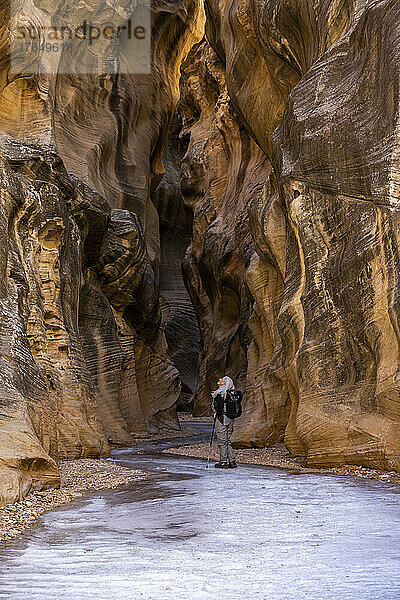 USA  Utah  Escalante  ältere Wanderin erkundet im Winter den Slot Canyon im Grand Staircase Escalante National Monument