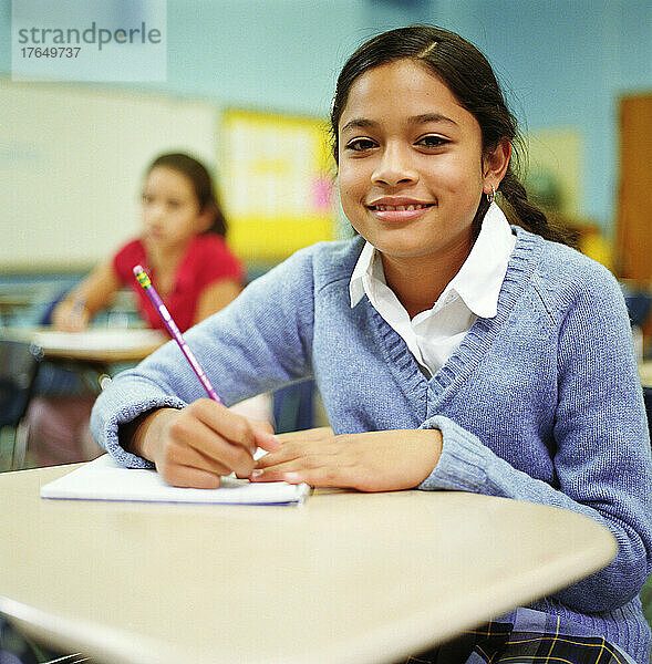 Porträt eines Mädchens (12-13)  das im Klassenzimmer sitzt