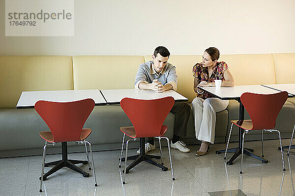 Kollegen diskutieren in der Cafeteria des Büros