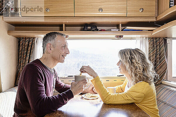 Älteres Paar isst im Urlaub Kekse im Wohnmobil