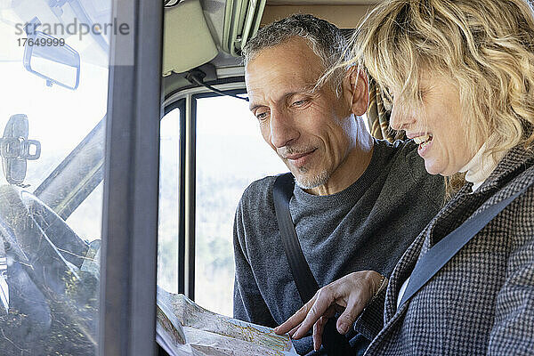 Älteres Paar schaut sich auf einer Wochenendreise die Karte an und unterhält sich im Wohnmobil