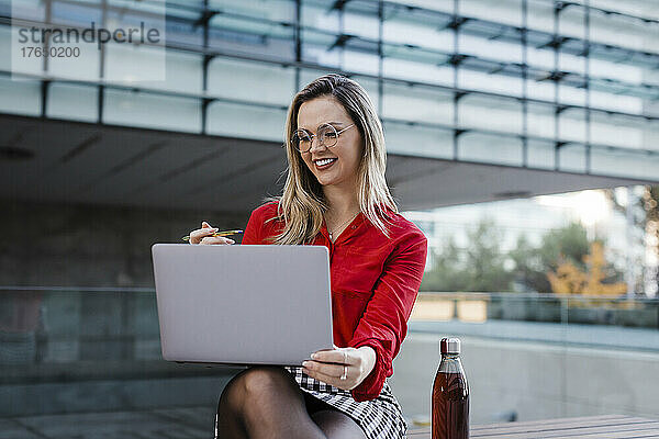 Lächelnde Geschäftsfrau  die am Laptop arbeitet