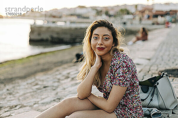 Junge Frau sitzt am Strand