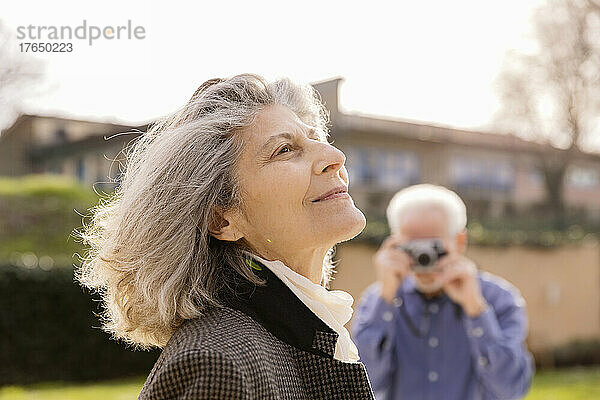 Älterer Mann fotografiert Frau an sonnigem Tag