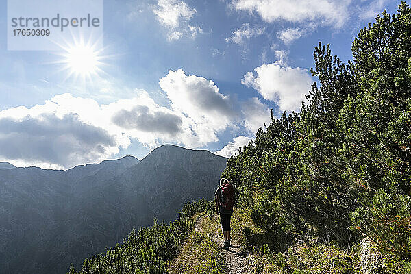 Die Sonne scheint über einer Wanderin im Karwendelgebirge