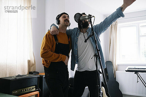 Musiker singen gemeinsam mit Mikrofon im Heimstudio