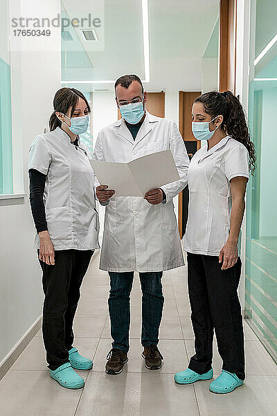 Arzt und Krankenschwestern besprechen medizinischen Bericht in der Kiefer- und Gesichtsklinik