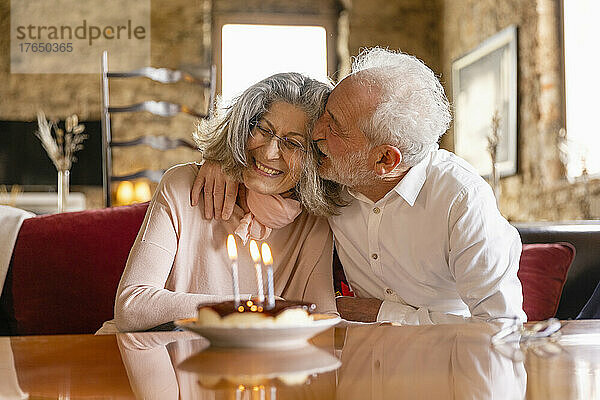 Glücklicher älterer Mann umarmt Frau  die Geburtstag im Boutique-Hotel feiert