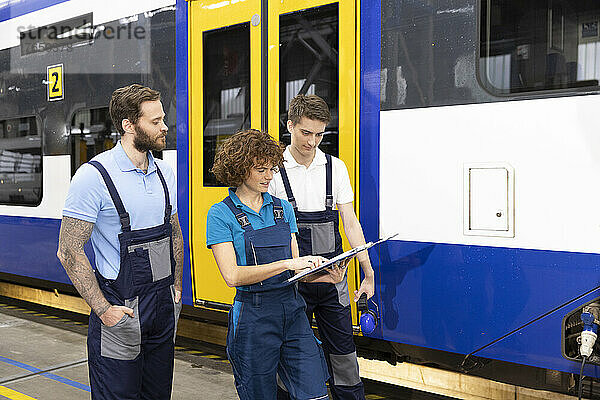 Ingenieur zeigt Auszubildenden in der Einschienenbahn in der Fabrik Aktenordner