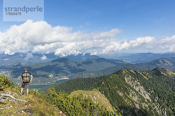 Männlicher Wanderer bewundert im Sommer den Blick auf den Sylvenstein-Stausee