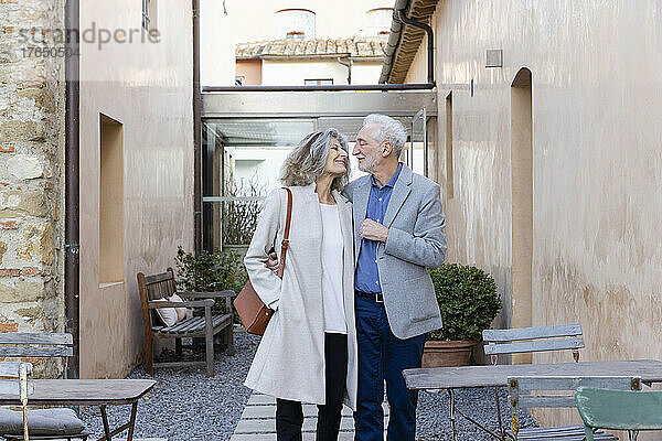 Glückliches älteres Paar  das einander im Innenhof des Hotels anschaut