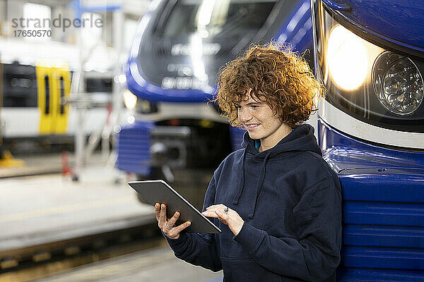 Ingenieur nutzt Tablet-PC und stützt sich in der Fabrik auf die Einschienenbahn