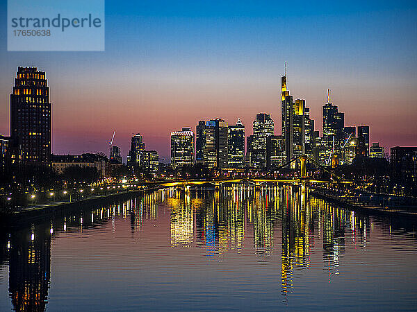 Deutschland  Hessen  Frankfurt  Mainkanal in der Abenddämmerung mit Brücke und Wolkenkratzern in der Innenstadt im Hintergrund