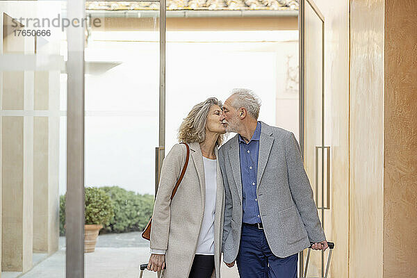 Älteres Paar küsst sich in der Lobby eines Boutique-Hotels