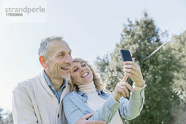 Fröhliches reifes Paar macht Selfie über das Handy