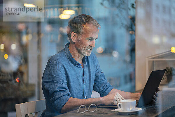 Businessman working on laptop at table in cafe